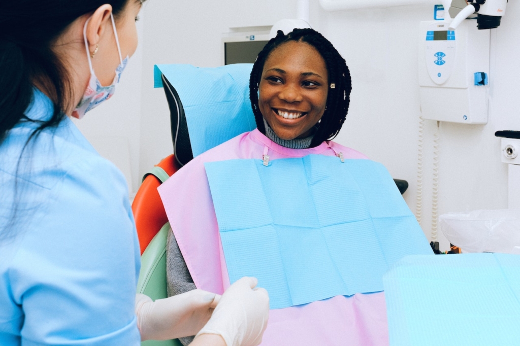A patient smiles at her dental hygenist